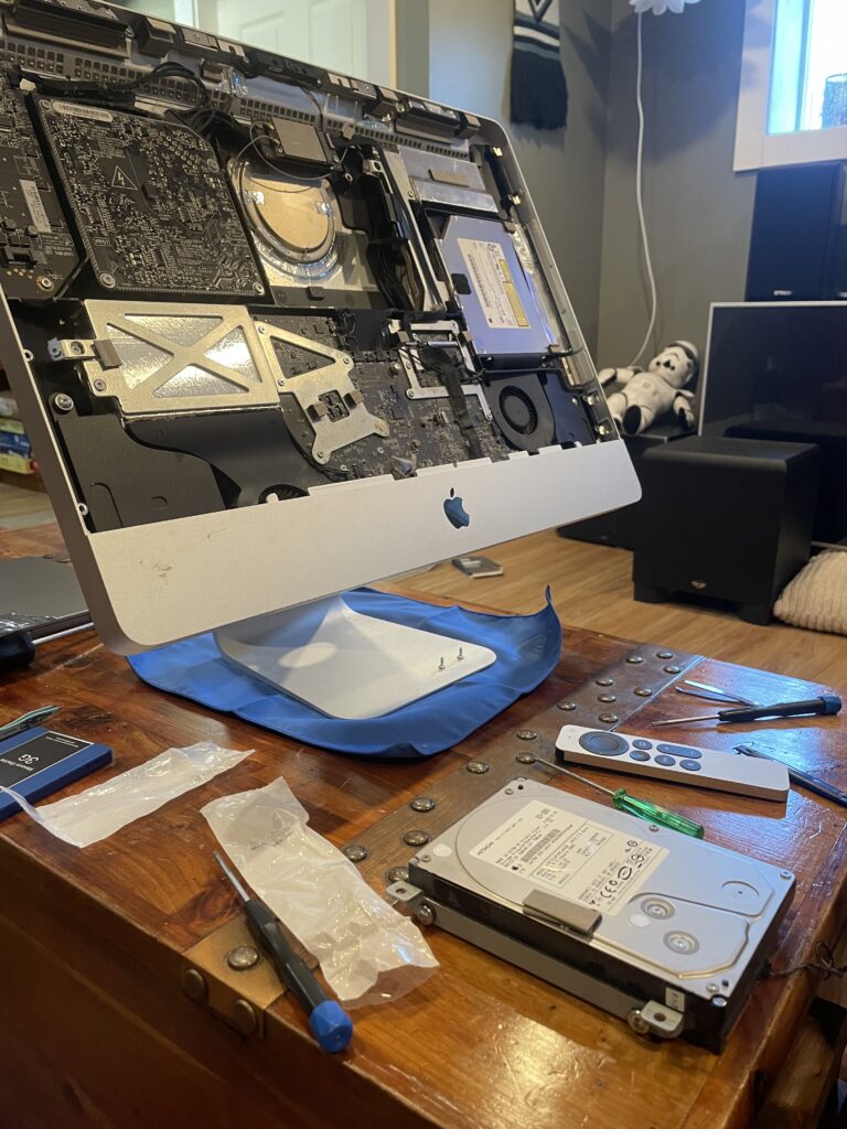 an iMac sits on a table. It has no screen. It's innards exposed.